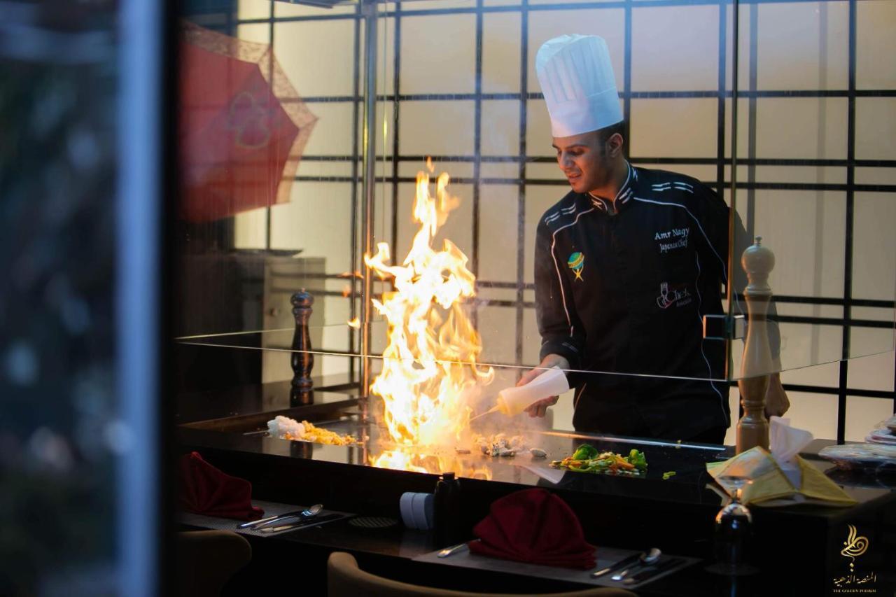 카사블랑카 그랜드 호텔 제다 외부 사진 A chef cooking with a flaming wok